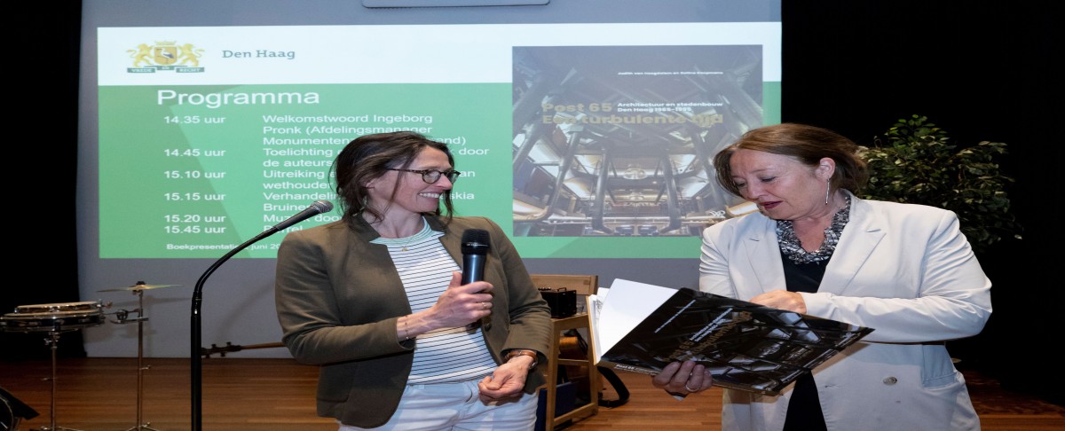 Teammanager Monumentenzorg en Welstand biedt het eerste exemplaar aan wethouder Saskia Bruines aan